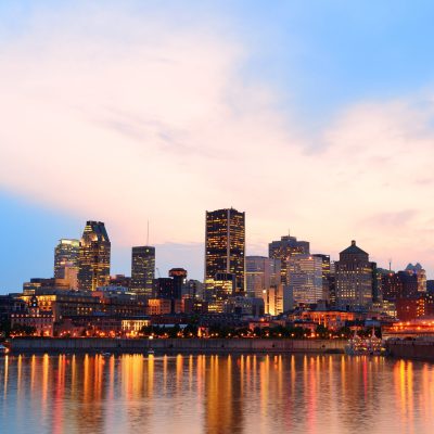 Montreal over river at sunset with city lights and urban buildings